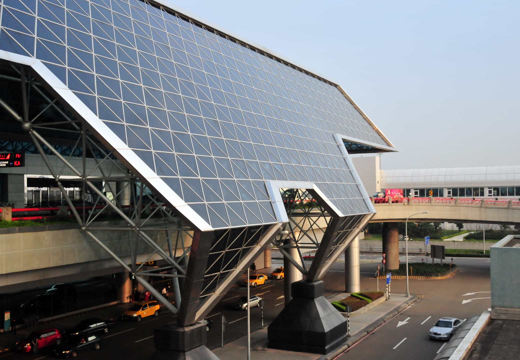 桃園國際機場大廳景象，旅客推著行李準備出發