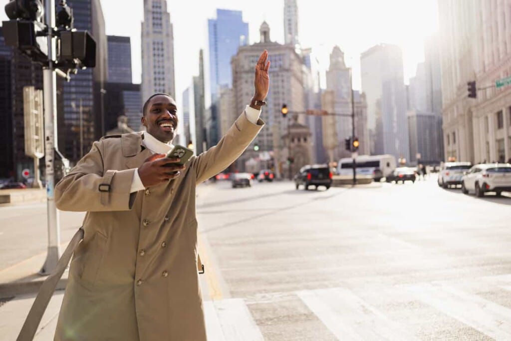 一名男性在都市街頭招車並拿著手機確認行程,突顯機場接送服務在城市旅遊中的重要性與即時性。 - 機場接送|首選24H 專車預約|全台接送服務推薦|奔旅派車 - 機場接送|首選24H 專車預約|全台接送服務推薦|奔旅派車 一名男性在都市街頭招車並拿著手機確認行程,突顯機場接送服務在城市旅遊中的重要性與即時性。